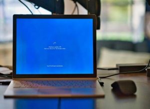 Laptop screen showing Windows update progress with a blue background