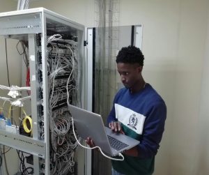 Technician working on server cables with laptop