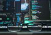 Computer code visible through glasses on a laptop