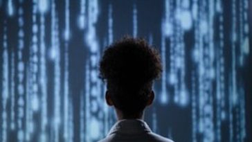 Person facing digital code display on screen